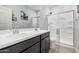 Bright bathroom with a double sink vanity, a large mirror, and glass shower enclosure, creating a spa-like atmosphere at 235 S 190Th Ave, Buckeye, AZ 85326