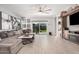 Bright living room with large sectional sofa, decorative shelves, a ceiling fan and outdoor views at 235 S 190Th Ave, Buckeye, AZ 85326