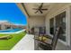 Covered patio with rocking chairs overlooking a backyard oasis with artificial turf, a pool, and clear blue skies at 235 S 190Th Ave, Buckeye, AZ 85326
