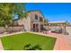 The house boasts a grassy backyard with covered patio seating, a luxurious pool, and an artificial lawn at 2454 W Camp River Rd, Queen Creek, AZ 85144
