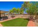 Well-maintained grassy backyard with a charming pergola, seating, and lush green landscaping at 2454 W Camp River Rd, Queen Creek, AZ 85144