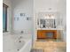 This bathroom features tile flooring, a soaking tub, a shower with glass door and a double-sink vanity at 2454 W Camp River Rd, Queen Creek, AZ 85144