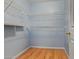 Walk-in closet featuring hardwood floors and built in wire shelving at 2454 W Camp River Rd, Queen Creek, AZ 85144