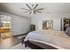 This main bedroom boasts wood flooring, a ceiling fan, a large bed, and a pass-through bathroom at 2454 W Camp River Rd, Queen Creek, AZ 85144