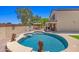 Backyard oasis with an in-ground pool, lounging area, and mature trees at 2454 W Camp River Rd, Queen Creek, AZ 85144