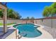 Inviting backyard pool with a Baja shelf and beautiful desert landscaping and clear blue sky at 2454 W Camp River Rd, Queen Creek, AZ 85144