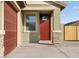 Inviting home entrance featuring a red front door, stone accents, and a covered porch, with a view of the garage at 2668 E San Miguel Dr, Casa Grande, AZ 85194