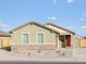 Charming single-story home with a red door and a well-maintained, low maintenance front yard on a sunny day at 2668 E San Miguel Dr, Casa Grande, AZ 85194