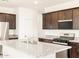 Well-lit kitchen boasting dark wood cabinets, stainless steel appliances, and granite countertops at 2668 E San Miguel Dr, Casa Grande, AZ 85194
