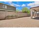 Brick paved backyard with planter against a block privacy wall, covered patio, and blue skies above at 2831 W Margy Ct, Phoenix, AZ 85017