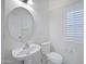 Powder room features a pedestal sink, round mirror, and crisp white wainscoting at 2831 W Margy Ct, Phoenix, AZ 85017