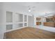 Bright open-concept living room with hardwood floors, built in shelving and a ceiling fan at 2831 W Margy Ct, Phoenix, AZ 85017