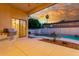 Covered patio features a built-in grill, with a view of free form pool with rock waterfall, with sunset views at 3001 E Winchcomb Dr, Phoenix, AZ 85032