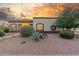 Charming home with desert landscaping, mature trees, and warm exterior lighting at 3001 E Winchcomb Dr, Phoenix, AZ 85032
