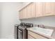 Updated laundry room featuring newer washer and dryer, lots of cabinet space, and a utility sink at 3001 E Winchcomb Dr, Phoenix, AZ 85032