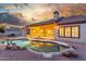 Back yard featuring desert landscaping and a free form pool with rock waterfall feature, and covered patio at 3001 E Winchcomb Dr, Phoenix, AZ 85032