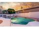 Back yard featuring desert landscaping and a free form pool with rock waterfall feature, and sunset sky at 3001 E Winchcomb Dr, Phoenix, AZ 85032