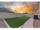 Back yard featuring low maintenance landscaping with a strip of synthetic turf and paver patio at 3001 E Winchcomb Dr, Phoenix, AZ 85032
