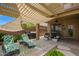 Cozy covered back patio with lounge chairs, outdoor grill, and lush greenery at 30013 N Candlewood Dr, San Tan Valley, AZ 85143