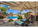 Relaxing backyard with a refreshing pool, lounge chairs and a covered patio at 30013 N Candlewood Dr, San Tan Valley, AZ 85143