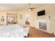 A primary bedroom with a fireplace, ceiling fan, and decorative artwork at 30013 N Candlewood Dr, San Tan Valley, AZ 85143