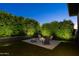 Cozy backyard with fire pit, Adirondack chairs, and privacy landscaping at 3145 E Boot Track Trl, Gilbert, AZ 85296