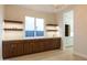 Elegant bar area featuring sleek wooden cabinets, floating shelves, and a stylish countertop with a modern faucet at 3145 E Boot Track Trl, Gilbert, AZ 85296