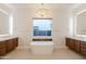 Spacious bathroom with and vanities, a soaking tub, and a large window at 3145 E Boot Track Trl, Gilbert, AZ 85296