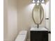 Modern bathroom with a black vanity, white countertop, and unique geometric mirror at 3145 E Boot Track Trl, Gilbert, AZ 85296