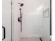Modern bathroom with a glass enclosed shower, gray tile floor, and black shower hardware at 3145 E Boot Track Trl, Gilbert, AZ 85296