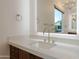 Elegant bathroom featuring a quartz countertop, sleek faucet, and decorative mirror at 3145 E Boot Track Trl, Gilbert, AZ 85296