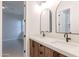 Modern bathroom featuring double vanity with white countertop and wood cabinets with black hardware at 3145 E Boot Track Trl, Gilbert, AZ 85296