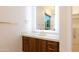 Elegant bathroom featuring a vanity with a lighted mirror, wood accents and gold hardware at 3145 E Boot Track Trl, Gilbert, AZ 85296