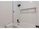 Clean bathroom featuring a tub with a shower and a tiled niche for storage at 3145 E Boot Track Trl, Gilbert, AZ 85296