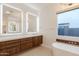 Bright bathroom featuring dual vanities, modern mirrors, and a freestanding tub at 3145 E Boot Track Trl, Gilbert, AZ 85296
