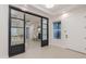 Welcoming entryway with sliding glass doors, leading to a playroom, and a white front door at 3145 E Boot Track Trl, Gilbert, AZ 85296