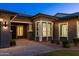 Charming home exterior featuring a brick accent, a well-lit porch, and professionally landscaped front yard at 3145 E Boot Track Trl, Gilbert, AZ 85296