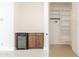 Hallway with built-in wine refrigerator and wood cabinets near a large shelved closet at 3145 E Boot Track Trl, Gilbert, AZ 85296