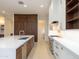 Modern kitchen with a large island, stainless steel appliances, and white and walnut cabinetry at 3145 E Boot Track Trl, Gilbert, AZ 85296