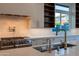 Modern kitchen with stainless steel gas range, bright tile backsplash, and double faucet sink at 3145 E Boot Track Trl, Gilbert, AZ 85296