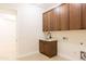 Functional laundry room with custom cabinets, a sink, and modern fixtures for convenience at 3145 E Boot Track Trl, Gilbert, AZ 85296