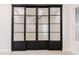 Living room featuring a black framed glass panel barn door leading to an open room with ceiling fan at 3145 E Boot Track Trl, Gilbert, AZ 85296