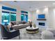 Bright living room with large windows, modern fireplace, comfortable seating, and stylish decor at 3145 E Boot Track Trl, Gilbert, AZ 85296