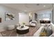Open-concept living room with modern decor, a peek into the kitchen, and a comfortable seating arrangement at 3145 E Boot Track Trl, Gilbert, AZ 85296