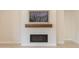 Cozy living room featuring a modern fireplace with a wooden mantel and a decorative floral painting at 3145 E Boot Track Trl, Gilbert, AZ 85296