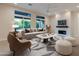 Bright living room with modern decor, a fireplace, and comfortable seating arrangement and views to the pool at 3145 E Boot Track Trl, Gilbert, AZ 85296