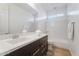 Bright bathroom featuring a single vanity, large mirror, and a combined shower and tub with white tiling at 3394 E Tiffany Ct, Gilbert, AZ 85298