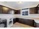Functional laundry room features ample cabinet space, a folding counter, and modern washer and dryer at 3394 E Tiffany Ct, Gilbert, AZ 85298
