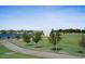 Scenic park view featuring a lake, green lawn, walking path, and modern white structure under a clear blue sky at 3394 E Tiffany Ct, Gilbert, AZ 85298