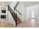 Hallway area featuring a staircase with dark railings, white walls, and tile flooring at 3394 E Tiffany Ct, Gilbert, AZ 85298